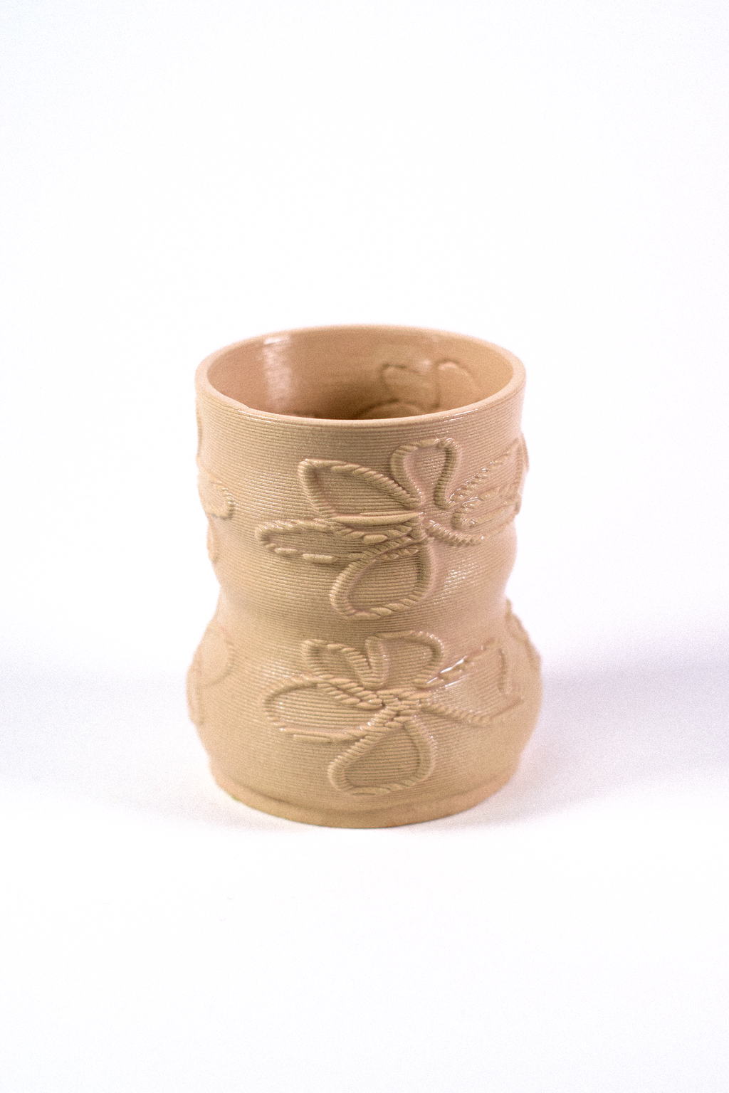 ashew-colored 3D-printed clay matcha cup featuring a textured flower silhouette pattern, designed by GLINA3.